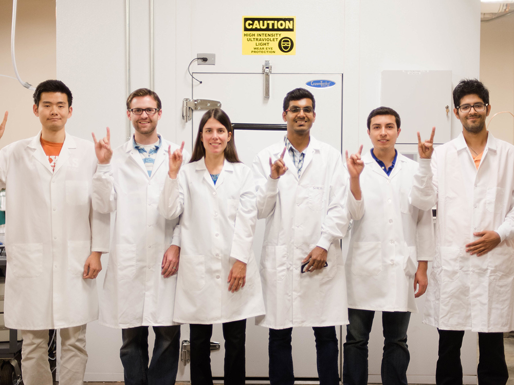 hildebrandt ruiz lab group showing hookem hand gesture