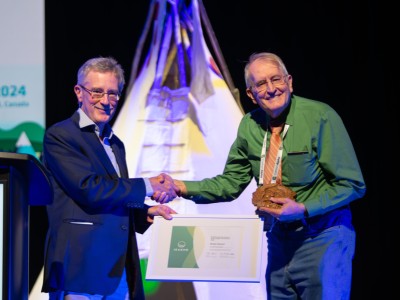 Tim Dixon awards Gary Rochelle with Greenman Award onstage