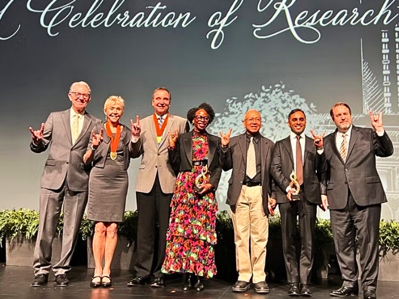 David Allen smiling with other awardees on-stage at the Celebration of Research