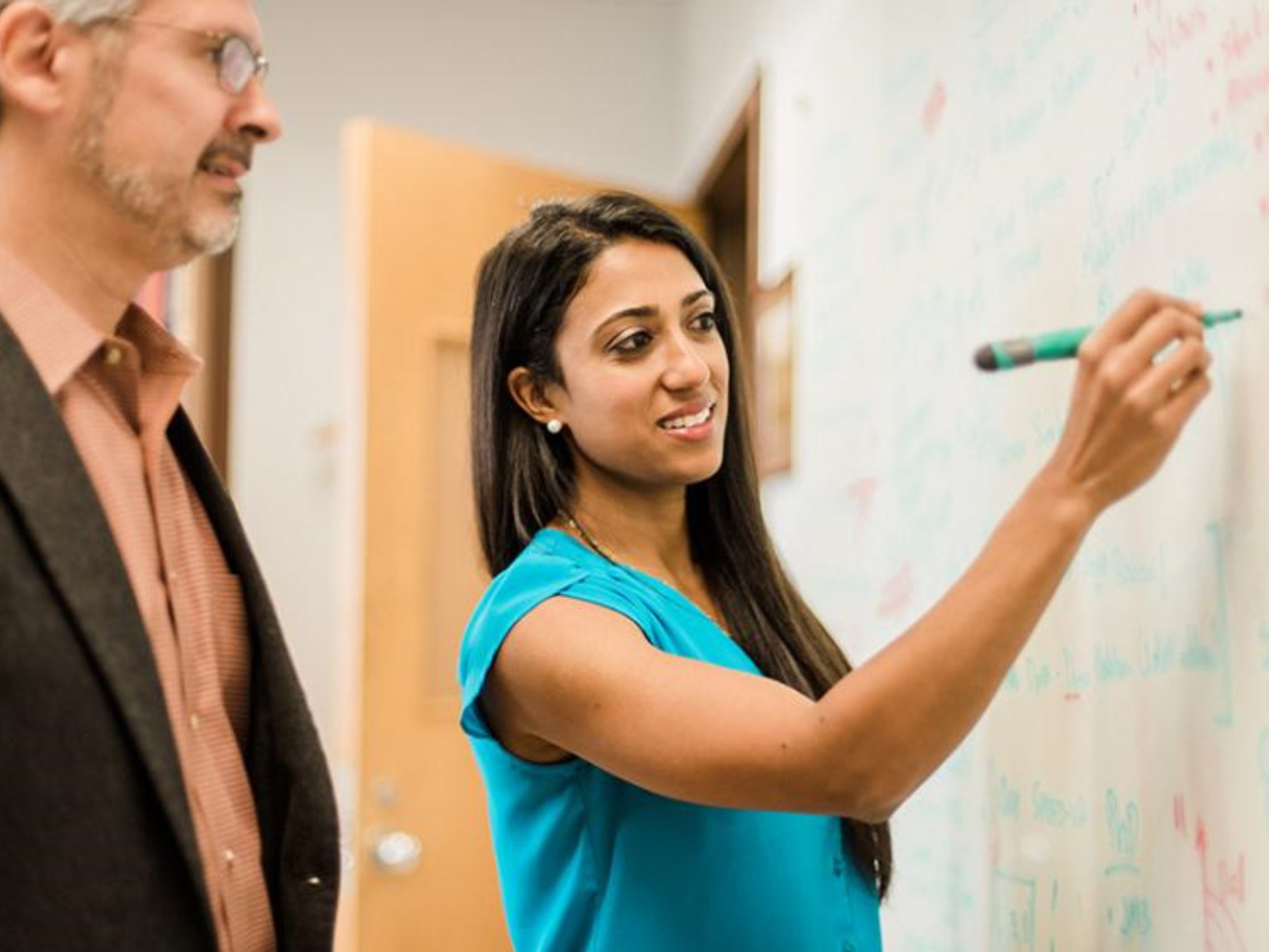 Texas Engineer drawing on whiteboard with Dean Roger Bonnecaze