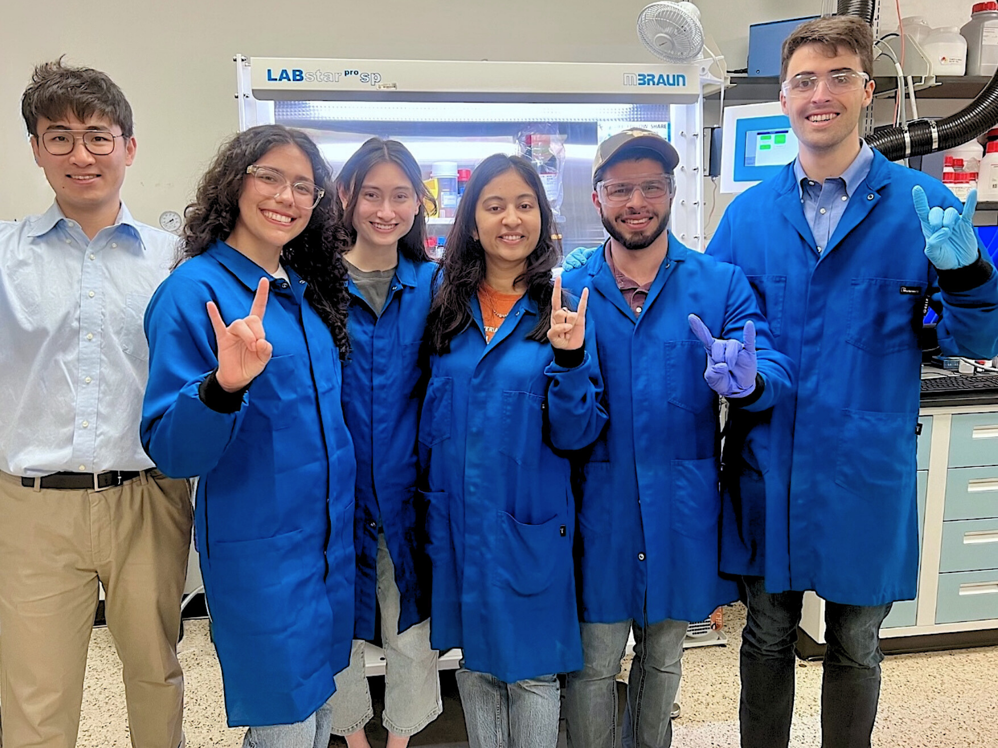Texas Engineer Kent Zheng smiling with his research group in a lab
