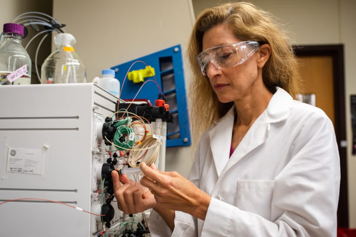 Texas Engineer Jennifer Maynard in lab coat and goggles in lab