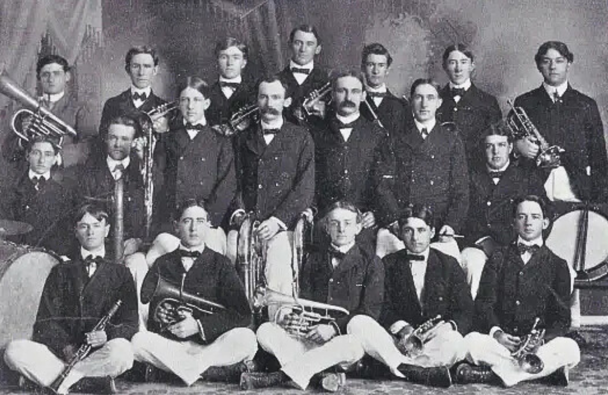 Black and white photo of previous band members posing with their instruments