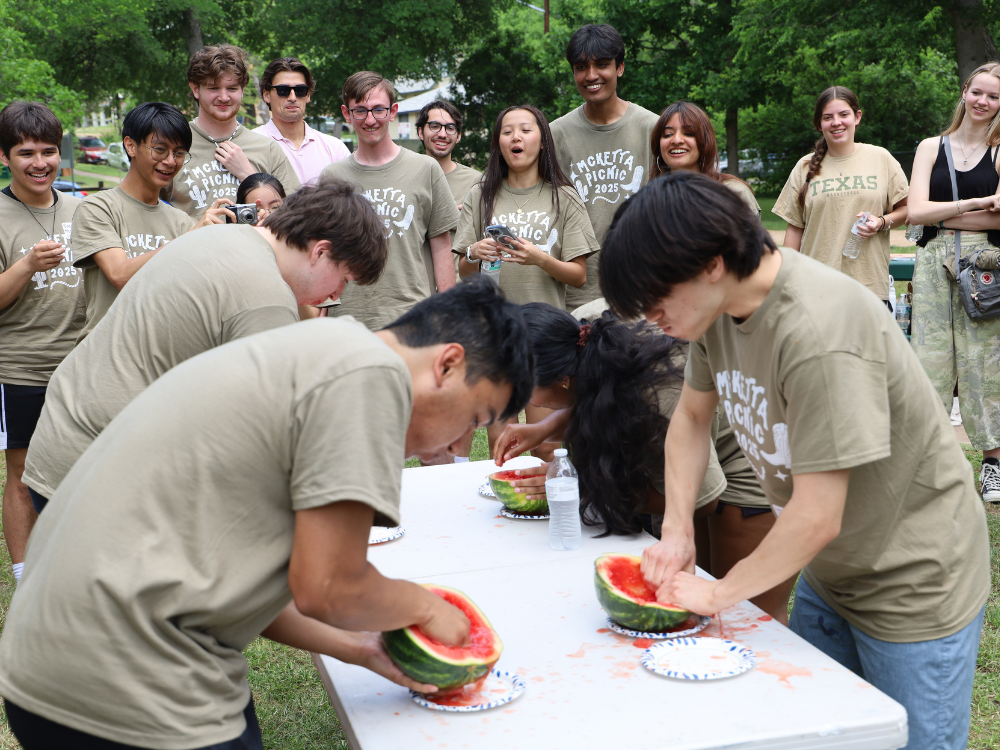Texas Chemical Engineering students and alumni participating in a watermelon eating contest
