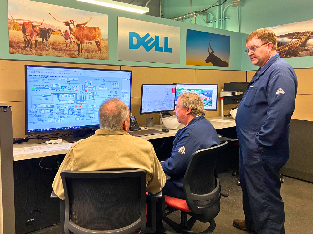 Gary Rochelle and Frank Seibert talking in front of large computer monitors