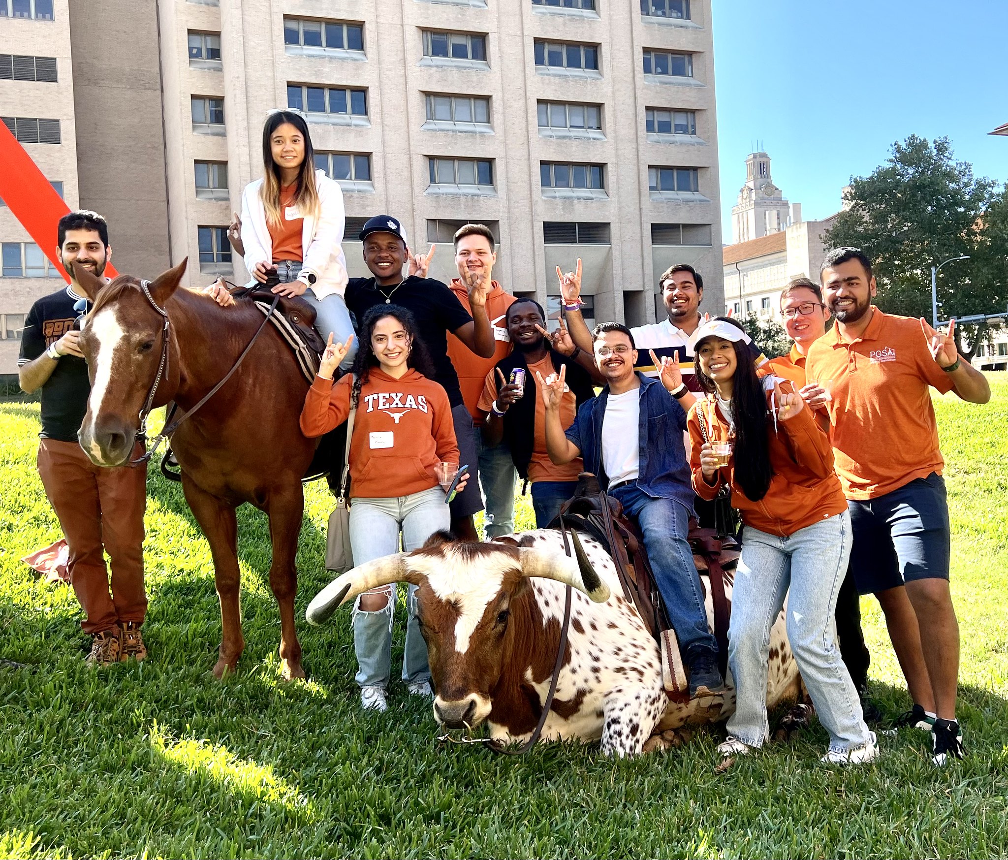 Texas chemical engineers smiling next to Longhorn