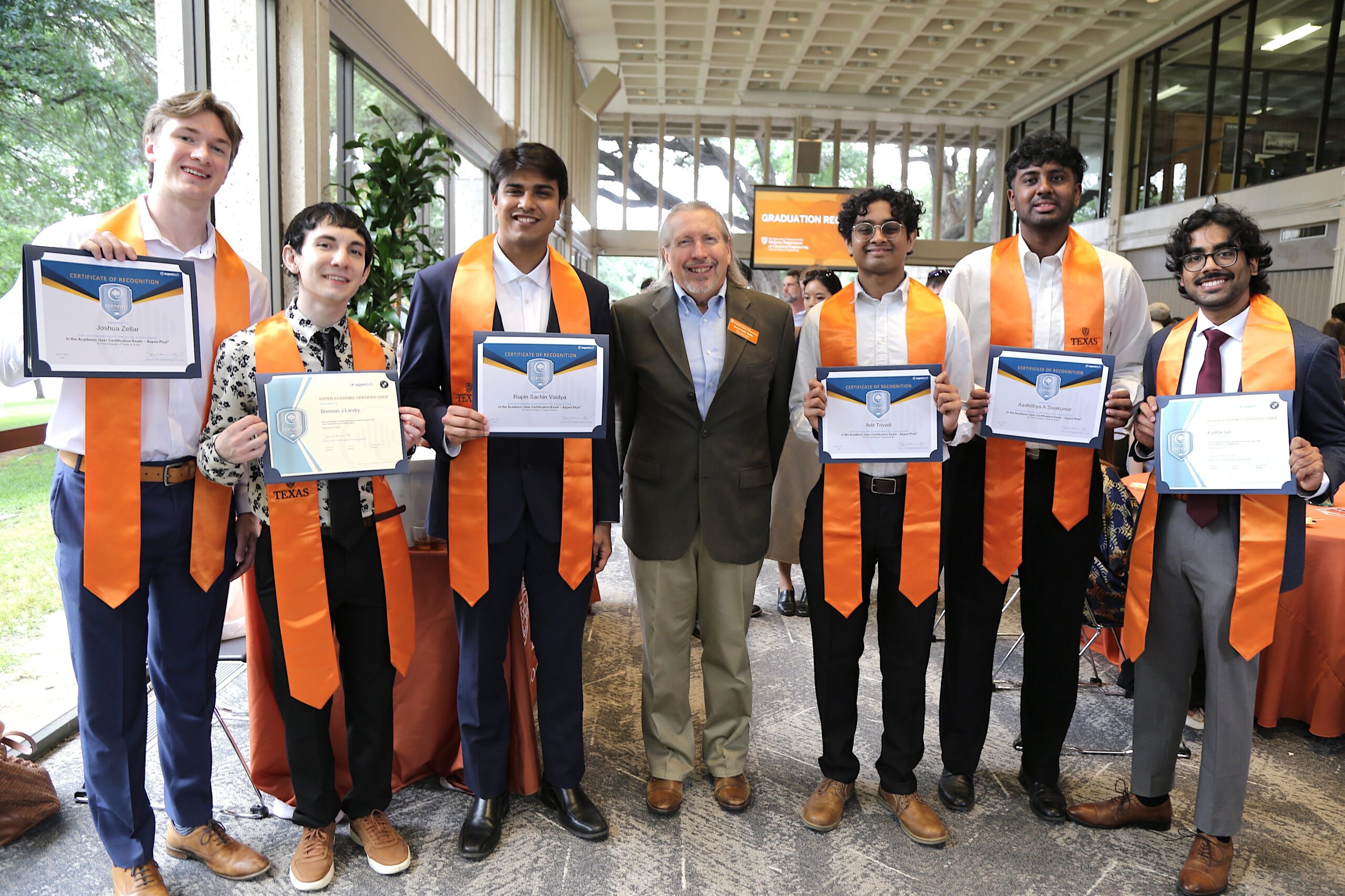 Texas ChE students holding up diplomas with professor David Dalle Molle