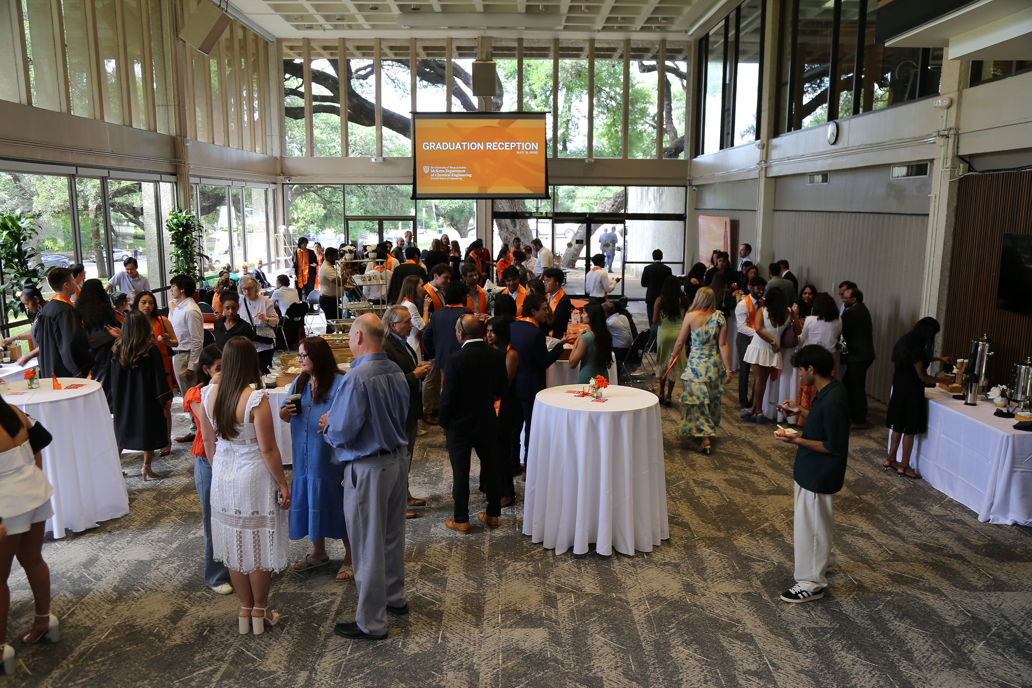 Large crowd of people socializing during ChE Graduation Reception event