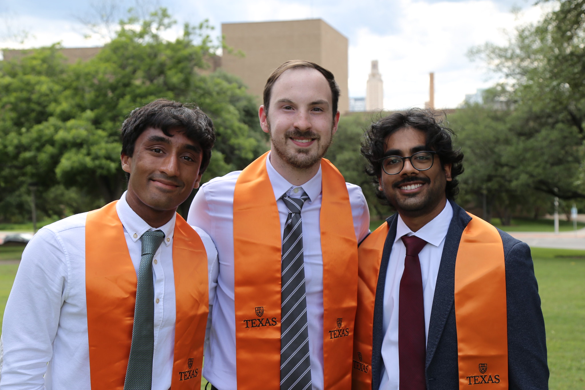 Texas chemical engineering students smiling together wearing graduation regalia
