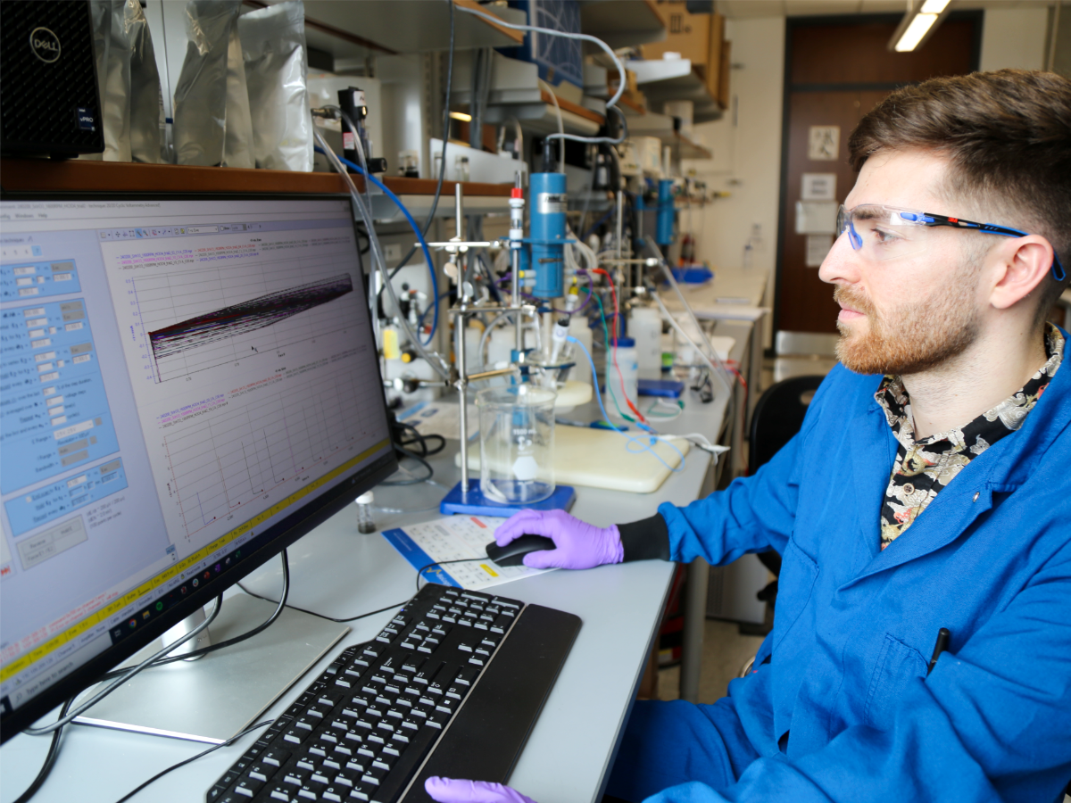 Texas chemical engineering student looking at computer in lab