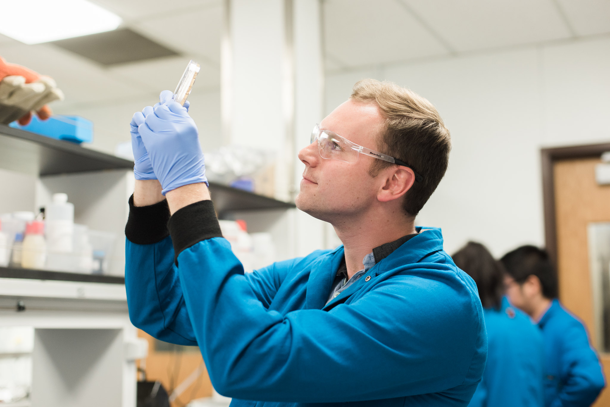 Texas chemical engineering researcher holding up test tube in lab